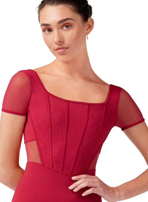 Woman wearing a red dress with sheer sleeves on a white background