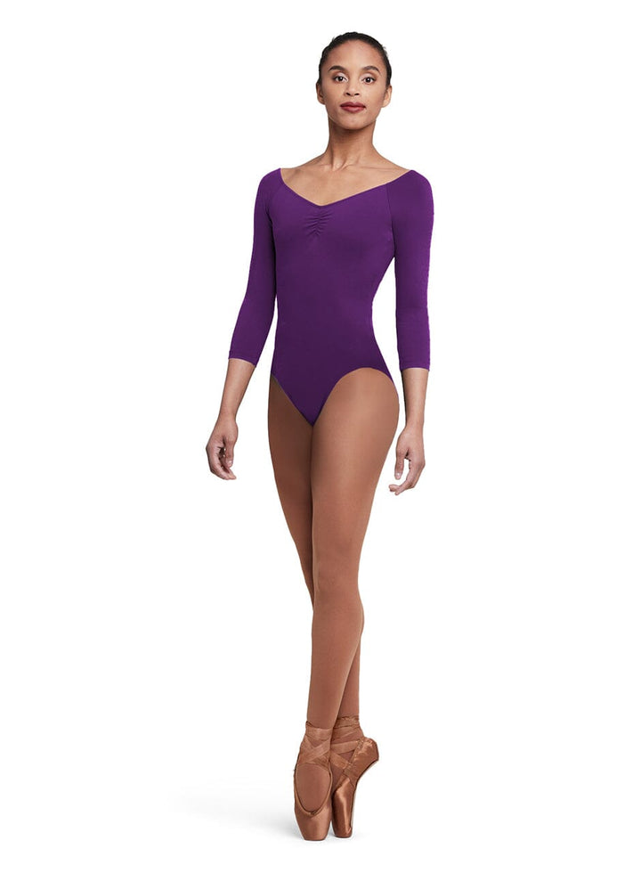 Dancer wearing a purple leotard and brown tights on a white background