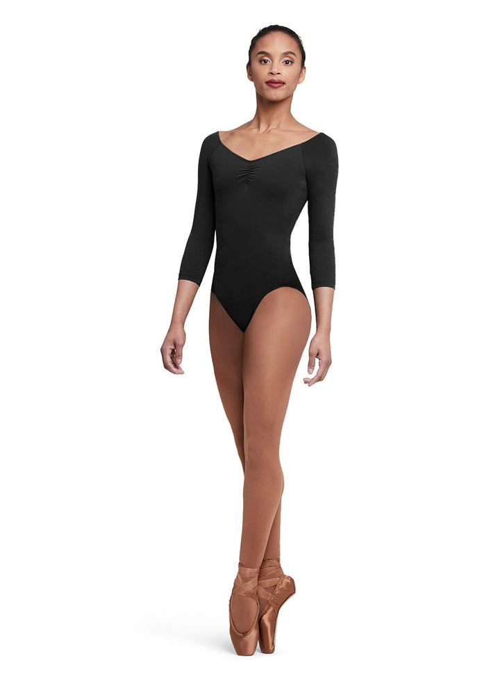 Dancer wearing a black leotard and brown tights on a white background
