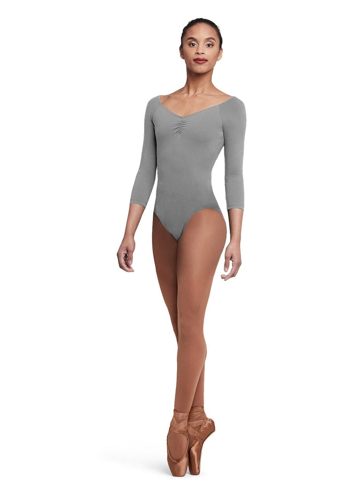 Dancer wearing a gray leotard and brown tights on a white background
