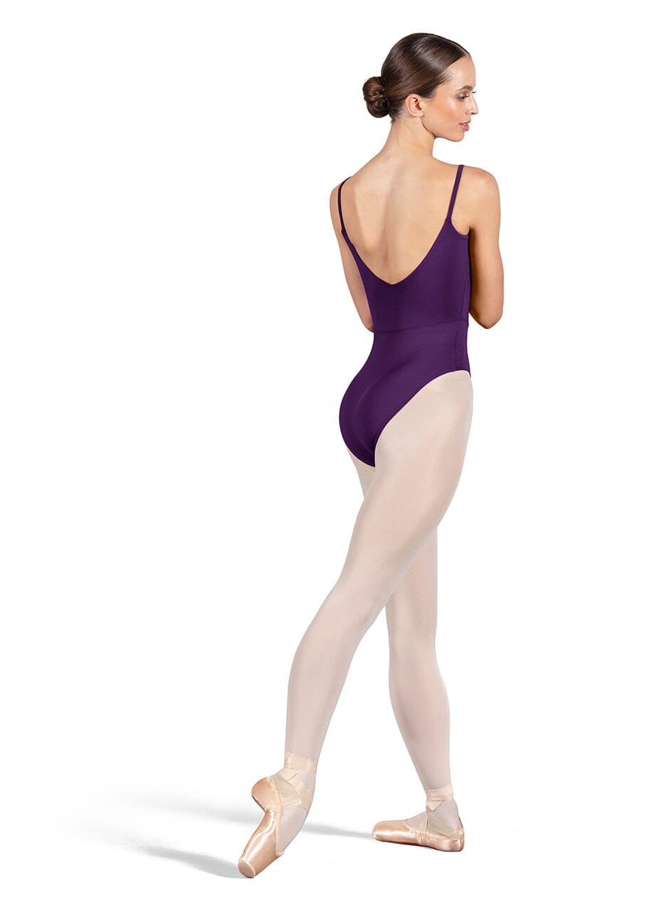 Ballerina in a purple leotard and beige tights on a white background