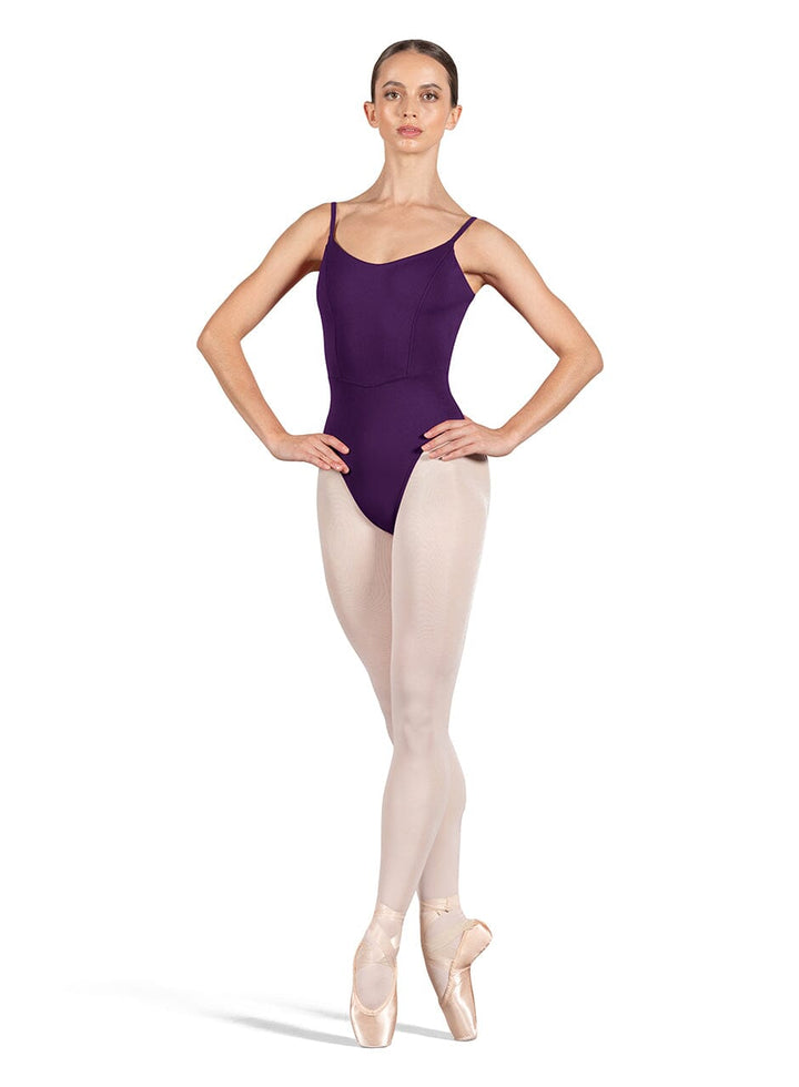 Ballerina wearing a purple leotard and beige tights on a white background