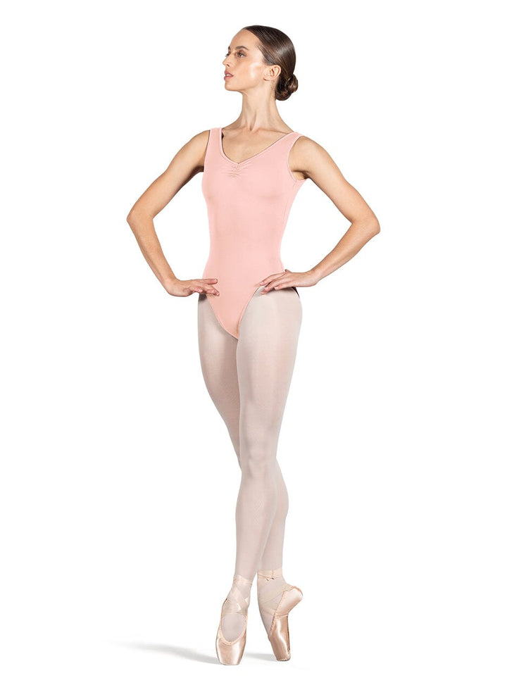 Ballerina in a pink leotard and beige tights on a white background
