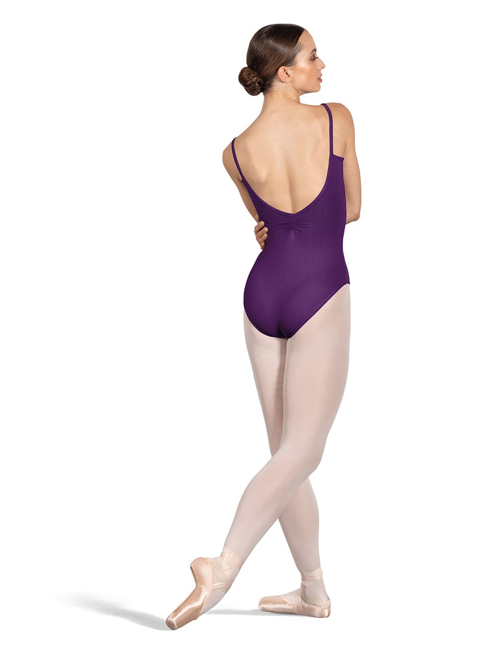 Ballerina in a purple leotard and pink tights on a white background