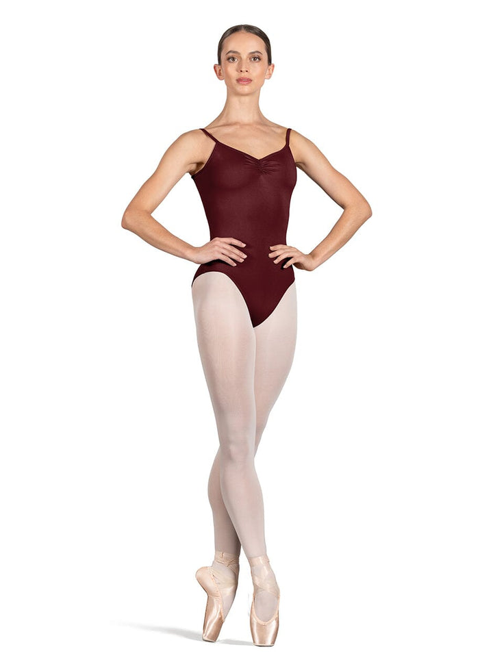 Ballerina wearing a maroon leotard and beige tights on a white background