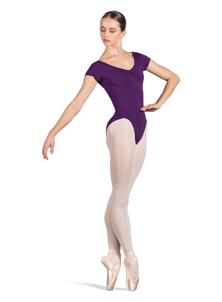 Ballerina in a purple leotard and beige tights on a white background