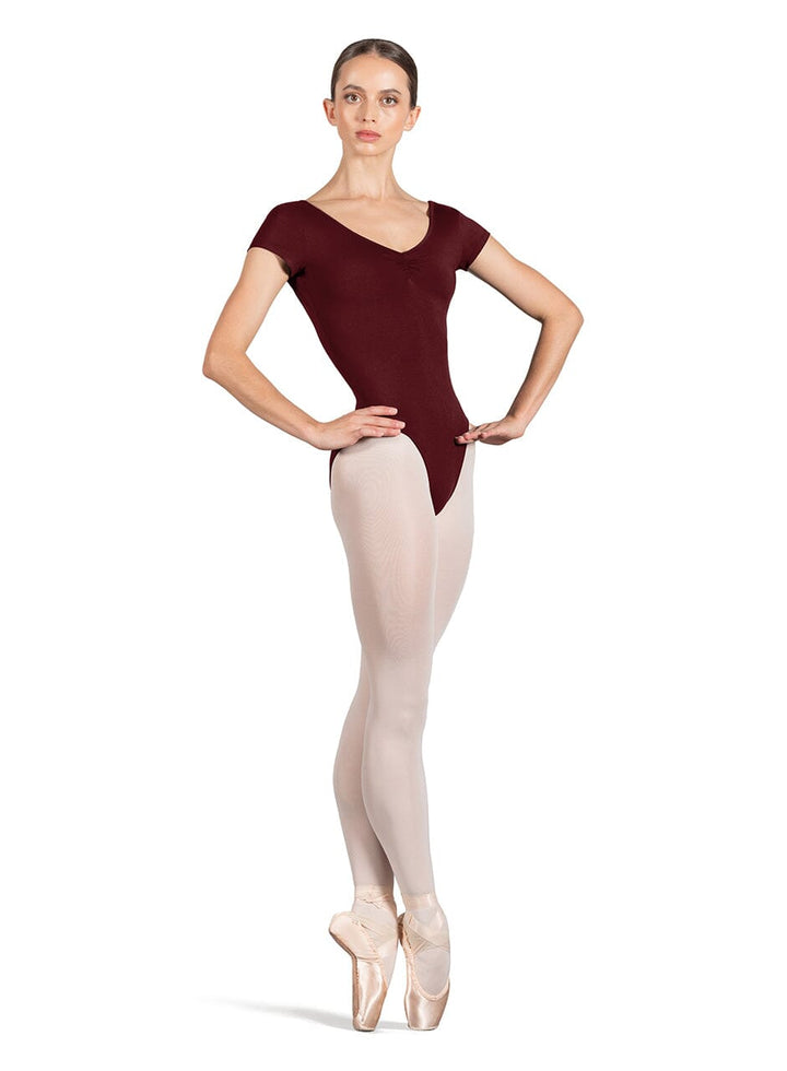 Ballerina in a maroon leotard and beige tights on a white background