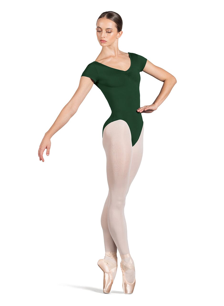 Dancer in a green leotard and white tights on a white background