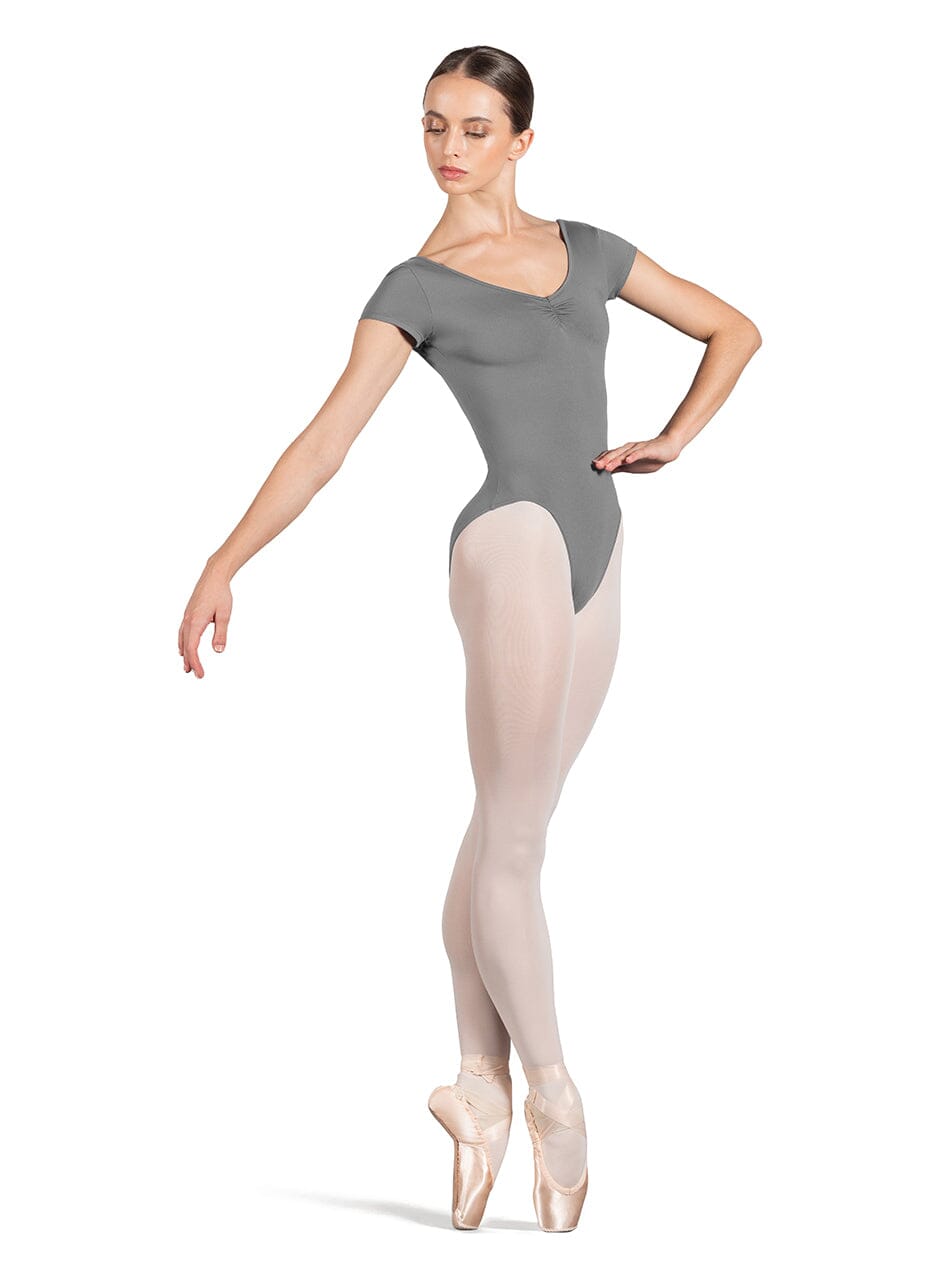 Ballerina in a gray leotard and beige tights on a white background