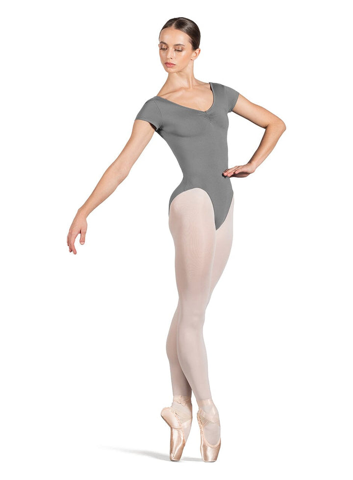 Ballerina in a gray leotard and beige tights on a white background