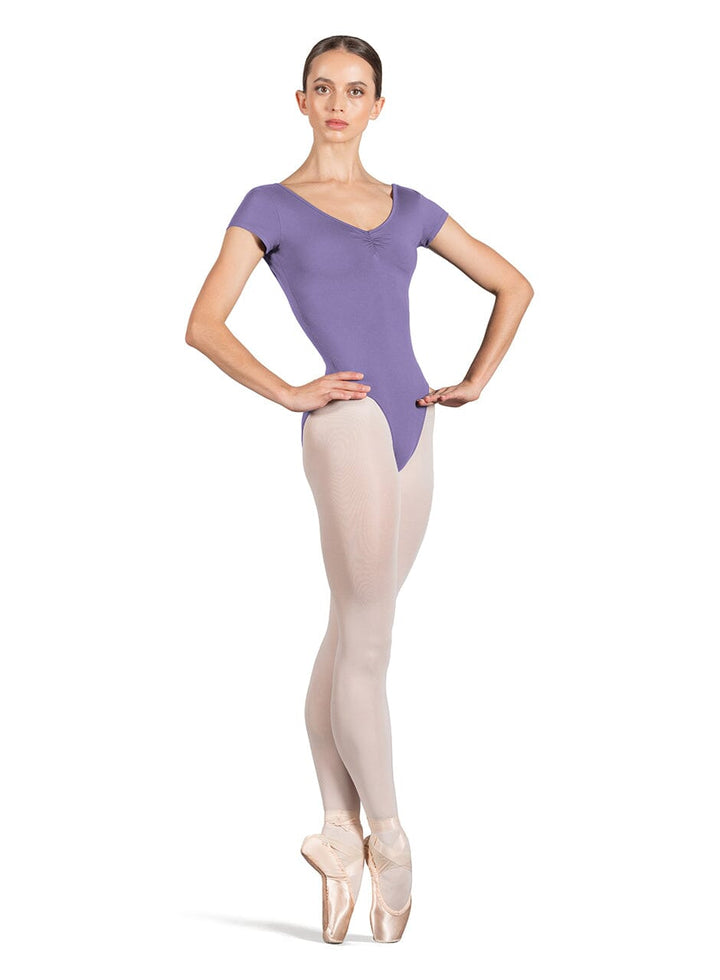 Ballerina in a purple leotard and beige tights on a white background