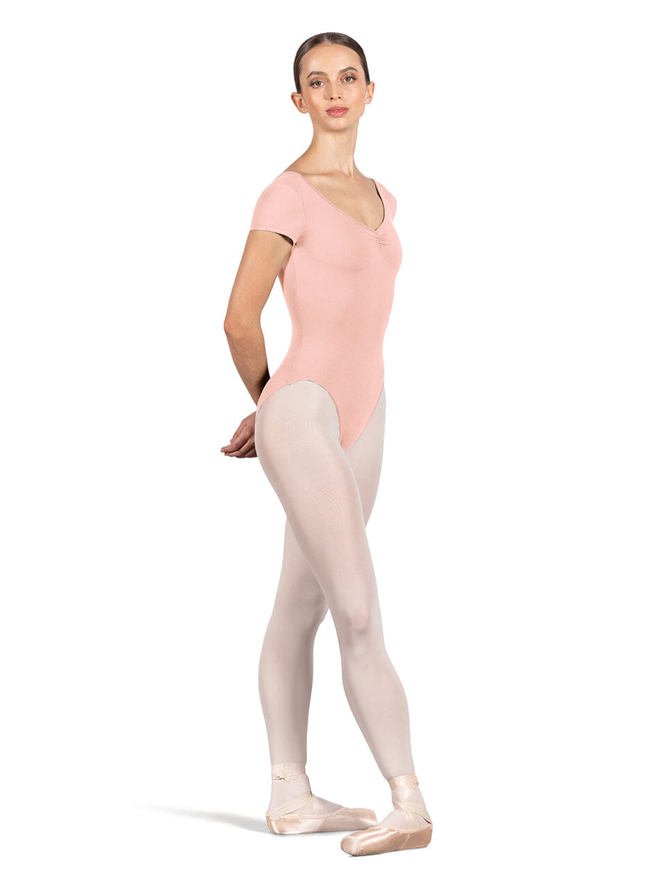 Ballerina in a pink leotard and beige tights on a white background