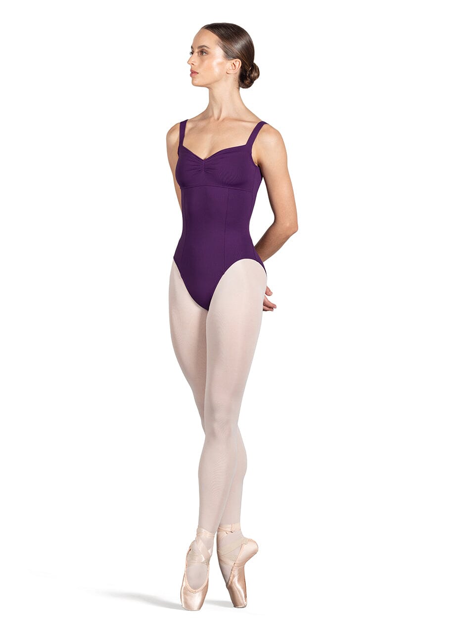 Ballerina in a purple leotard and beige tights on a white background