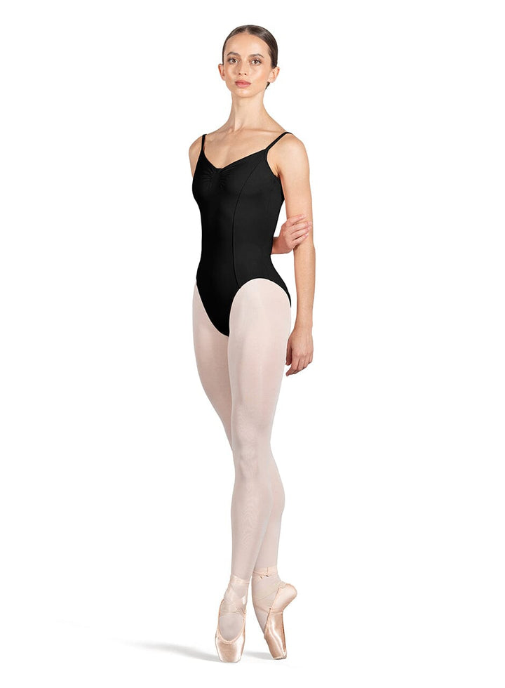 Ballerina wearing a black leotard and beige tights on a white background