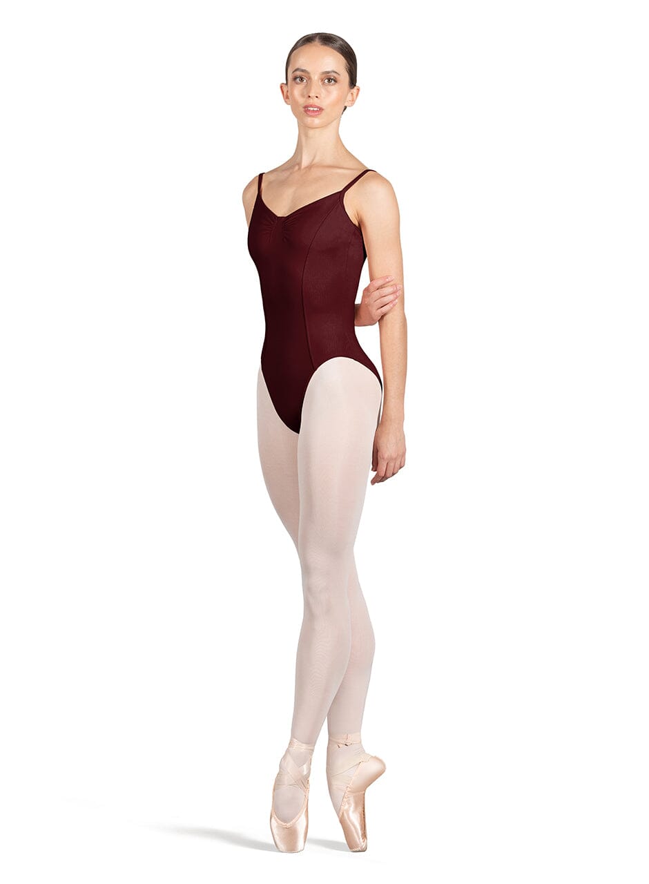 Ballerina wearing a dark red leotard and beige tights on a white background