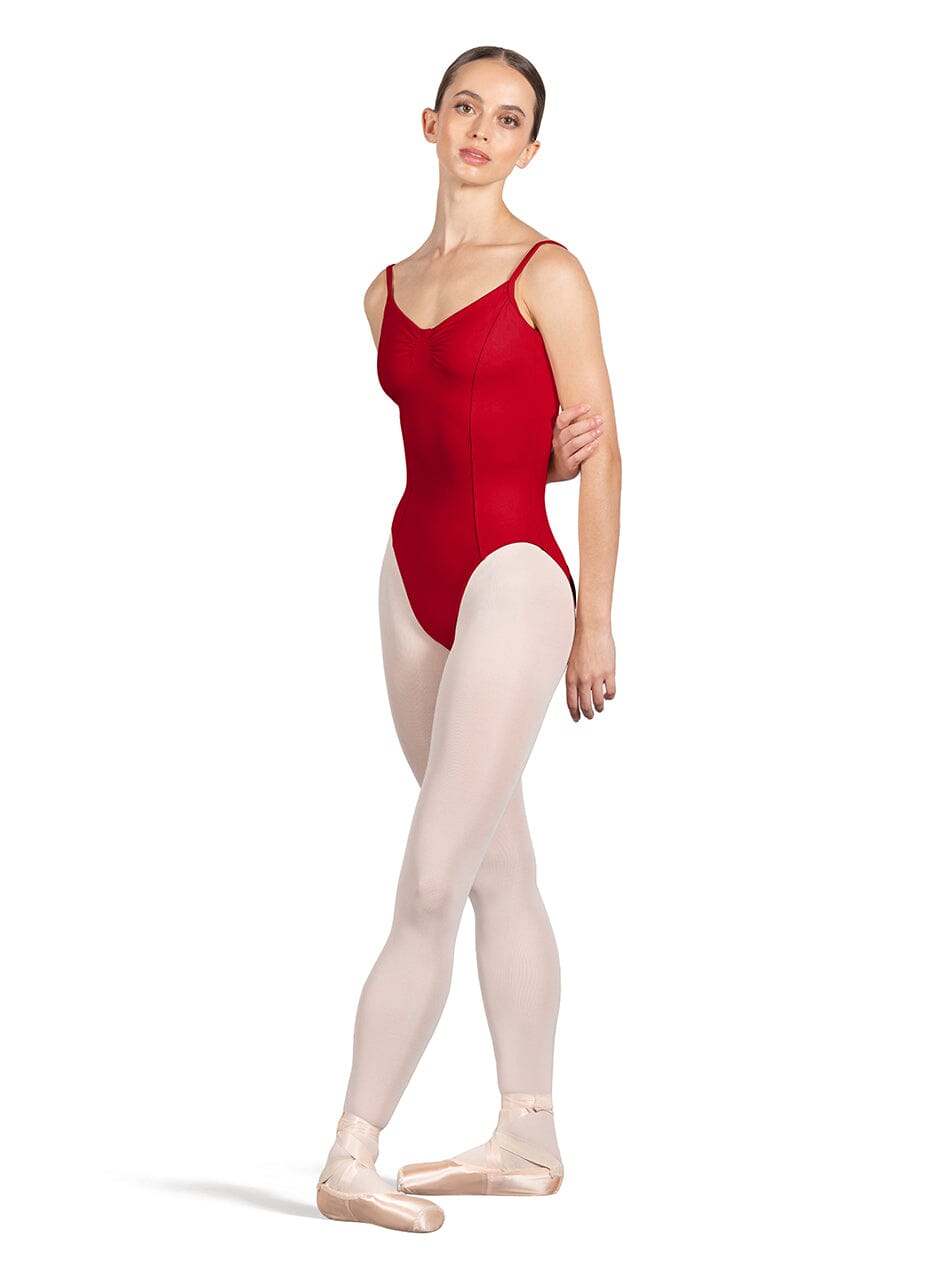 Ballerina wearing a red leotard and beige tights on a white background