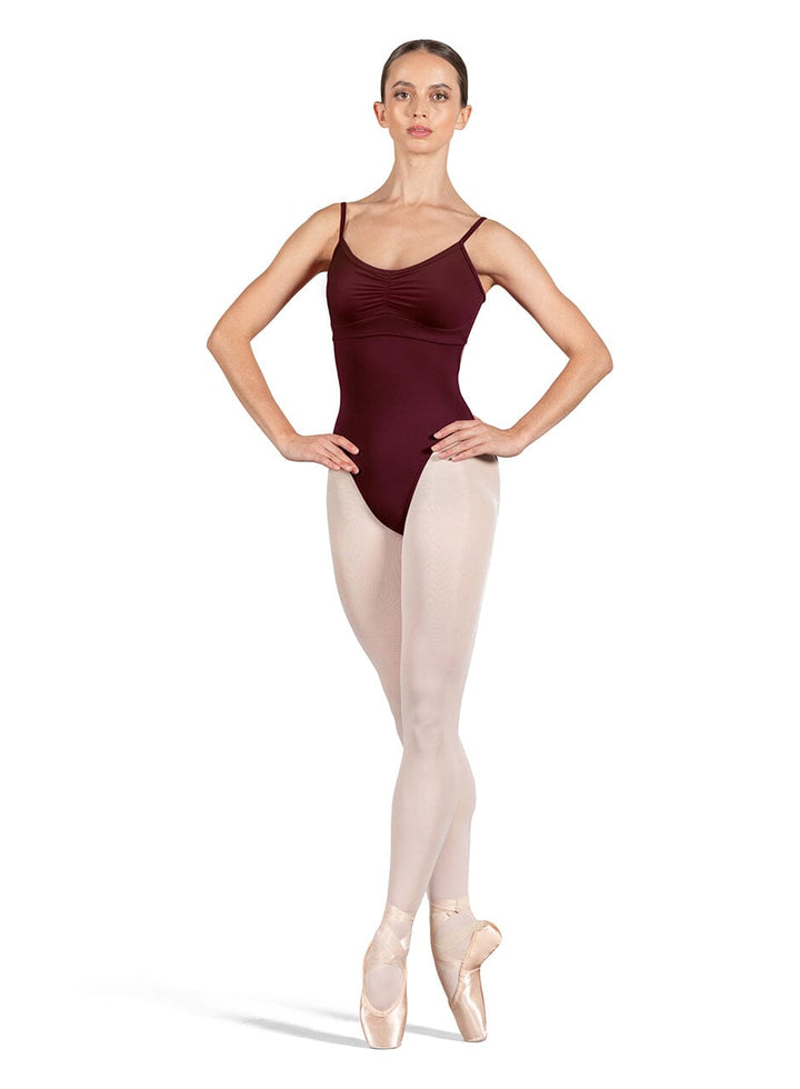 Ballet dancer wearing a maroon leotard and beige tights on a white background