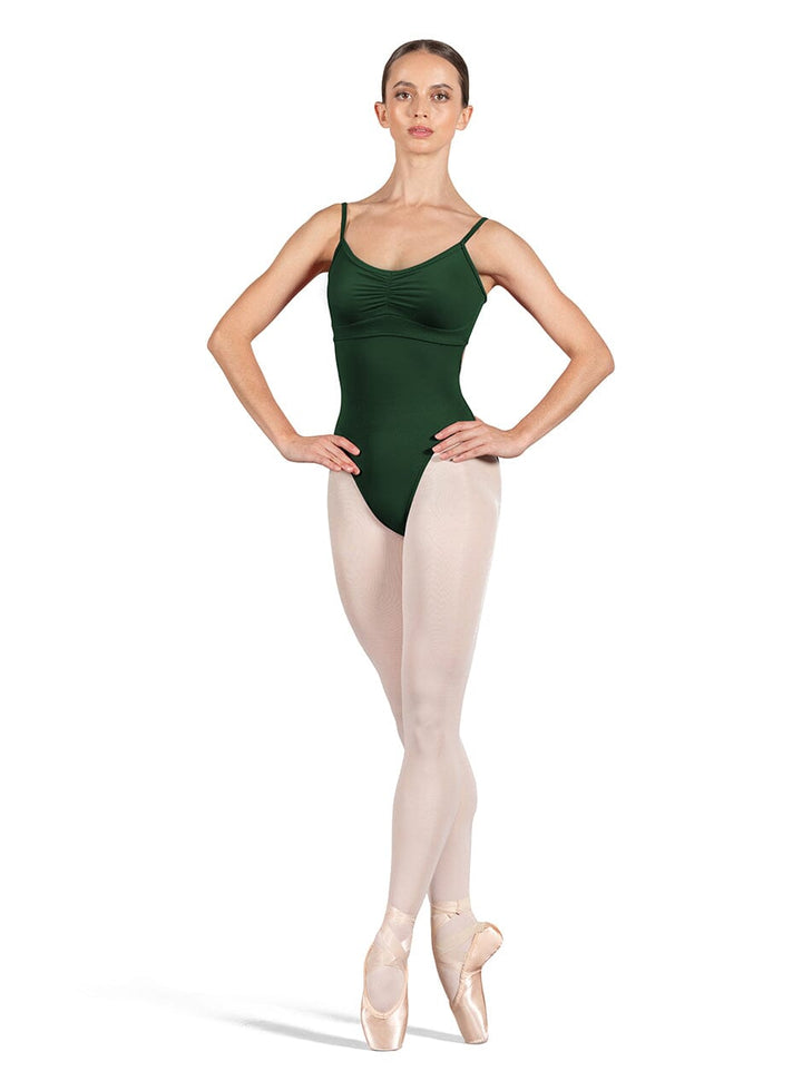 Dancer wearing a green leotard and beige tights on a white background
