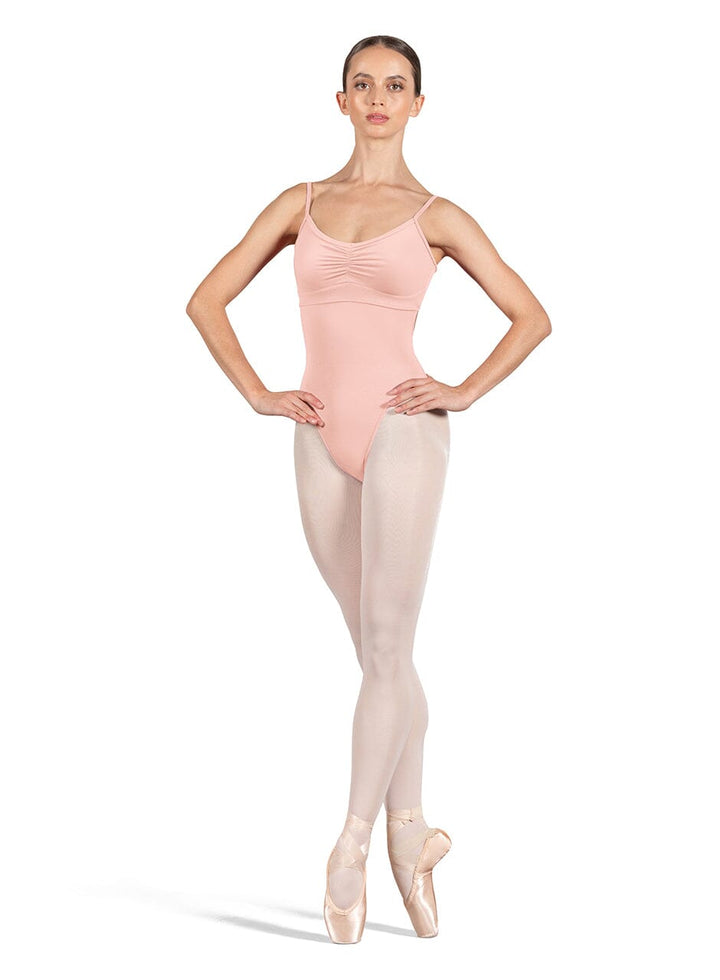 Ballerina in a pink leotard and beige tights on a white background