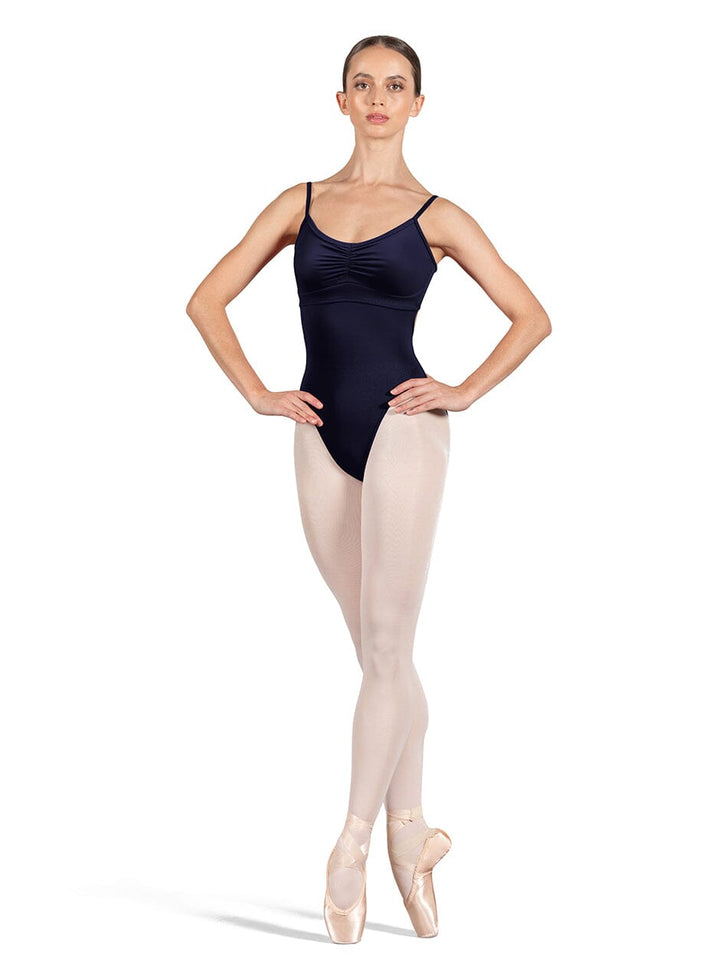 Ballerina in a navy leotard and beige tights on a white background