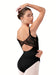 Woman wearing a black leotard with sheer mesh panels on a white background