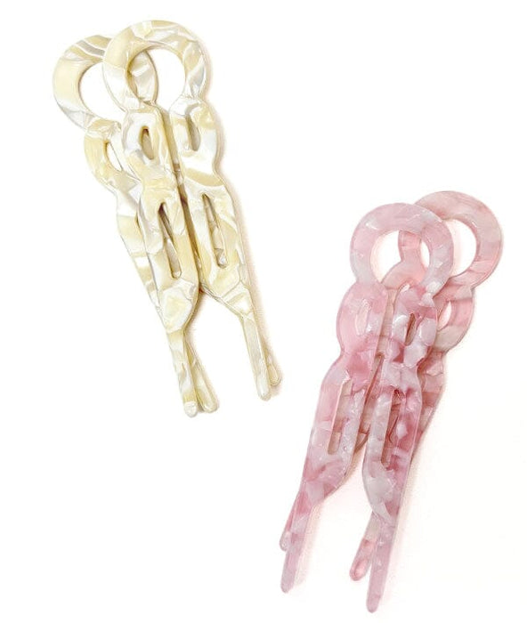 Two hair clips, one beige and one pink, on a white background