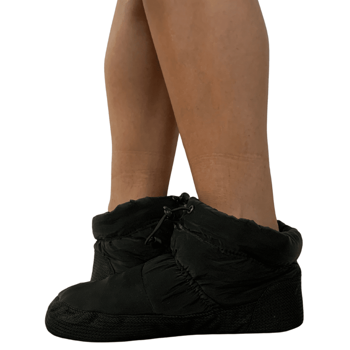 Black shoe covers over shoes on a white background