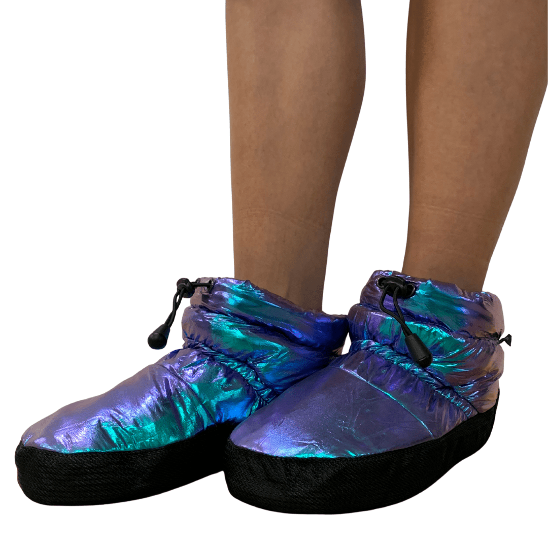 Iridescent shoes worn by a person on a white background