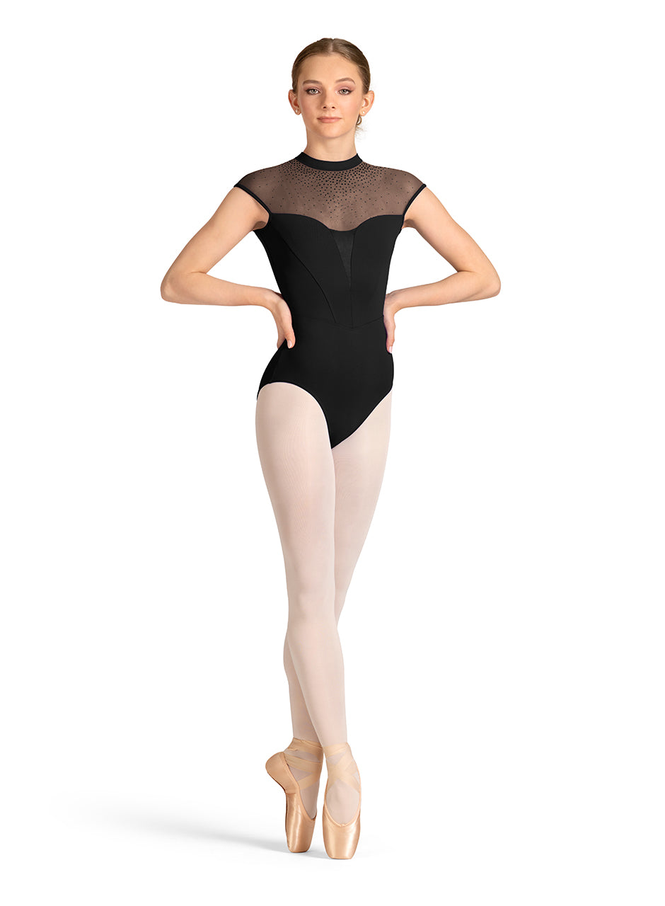Ballerina wearing a black leotard and beige tights on a white background