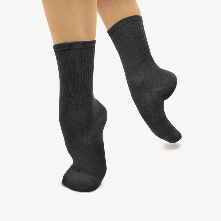 Black socks worn by a person on a white background