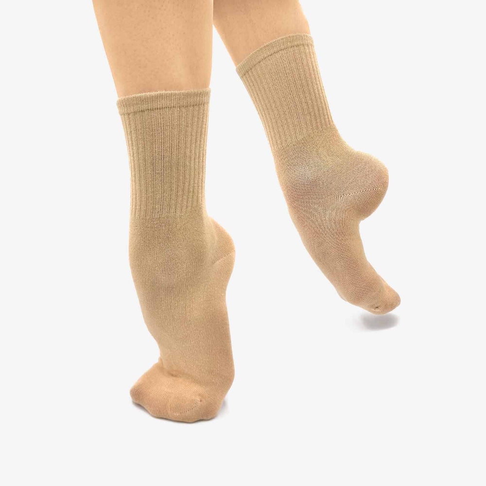 Beige knee-high socks worn by a person on a white background