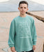 Child wearing a teal sweatshirt with a graphic design outdoors