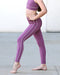 Person wearing purple leggings with white stripes on a neutral background