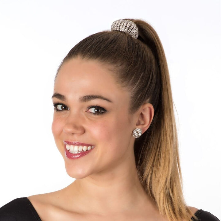 Woman with a high ponytail wearing a decorative hair tie and earrings on a white background