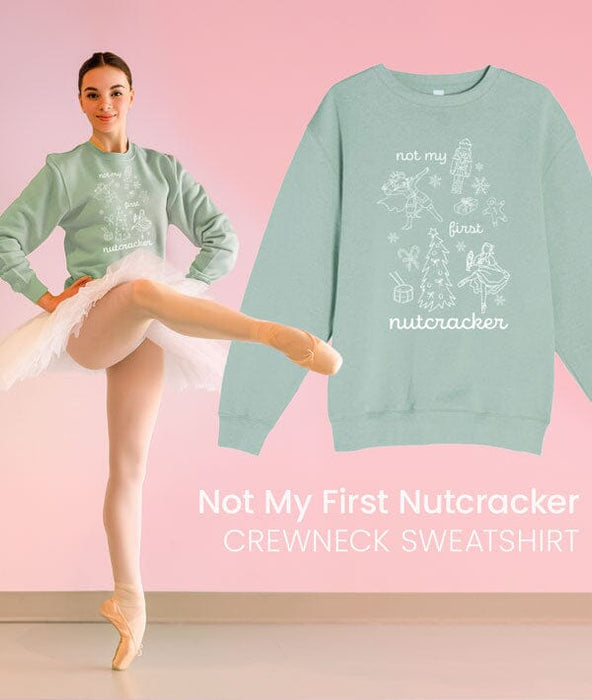 Woman in ballet outfit with 'Not My First Nutcracker' sweatshirt on pink background