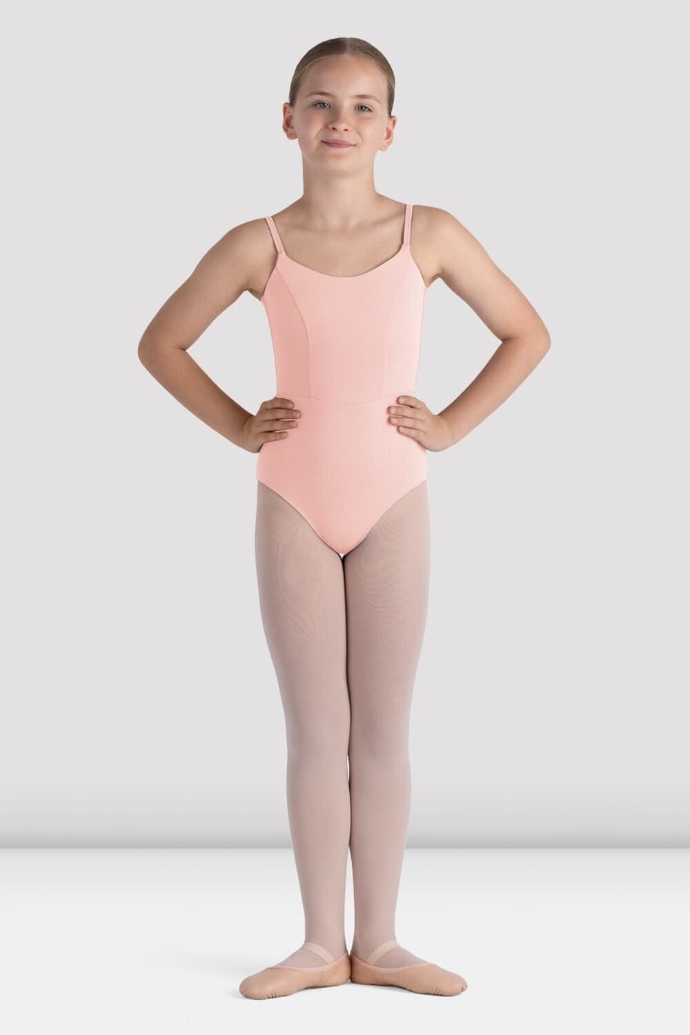 Young girl wearing a pink leotard and beige tights on a white background
