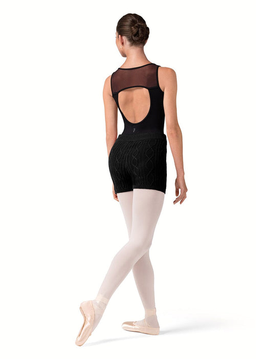 Ballerina in a black leotard and white tights on a white background