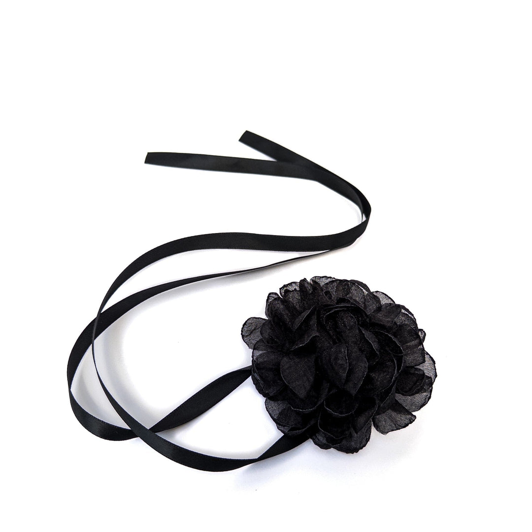 Black flower headband with ribbons on a white background