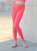 Person wearing bright pink leggings standing against a neutral background