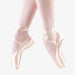 Ballet shoes worn with pink tights on a white background
