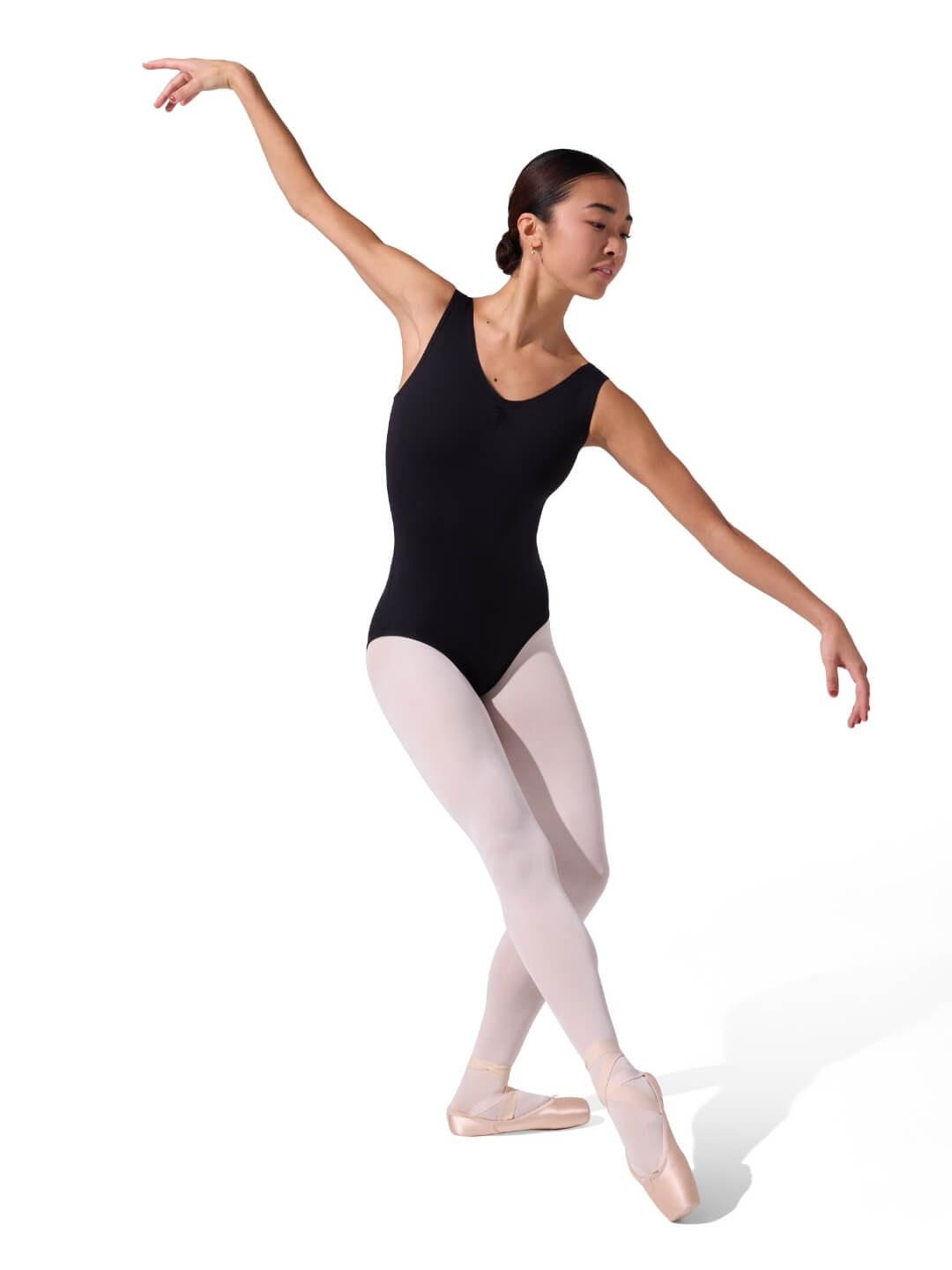 Ballerina in a black leotard and white tights posing on a white background