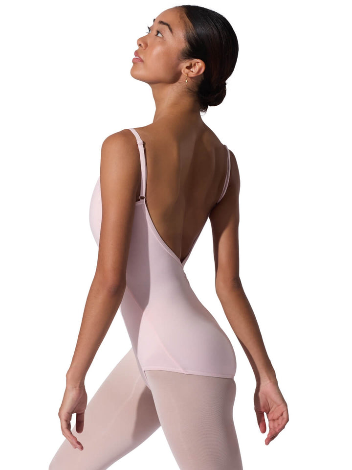 Woman wearing a light pink leotard on a white background