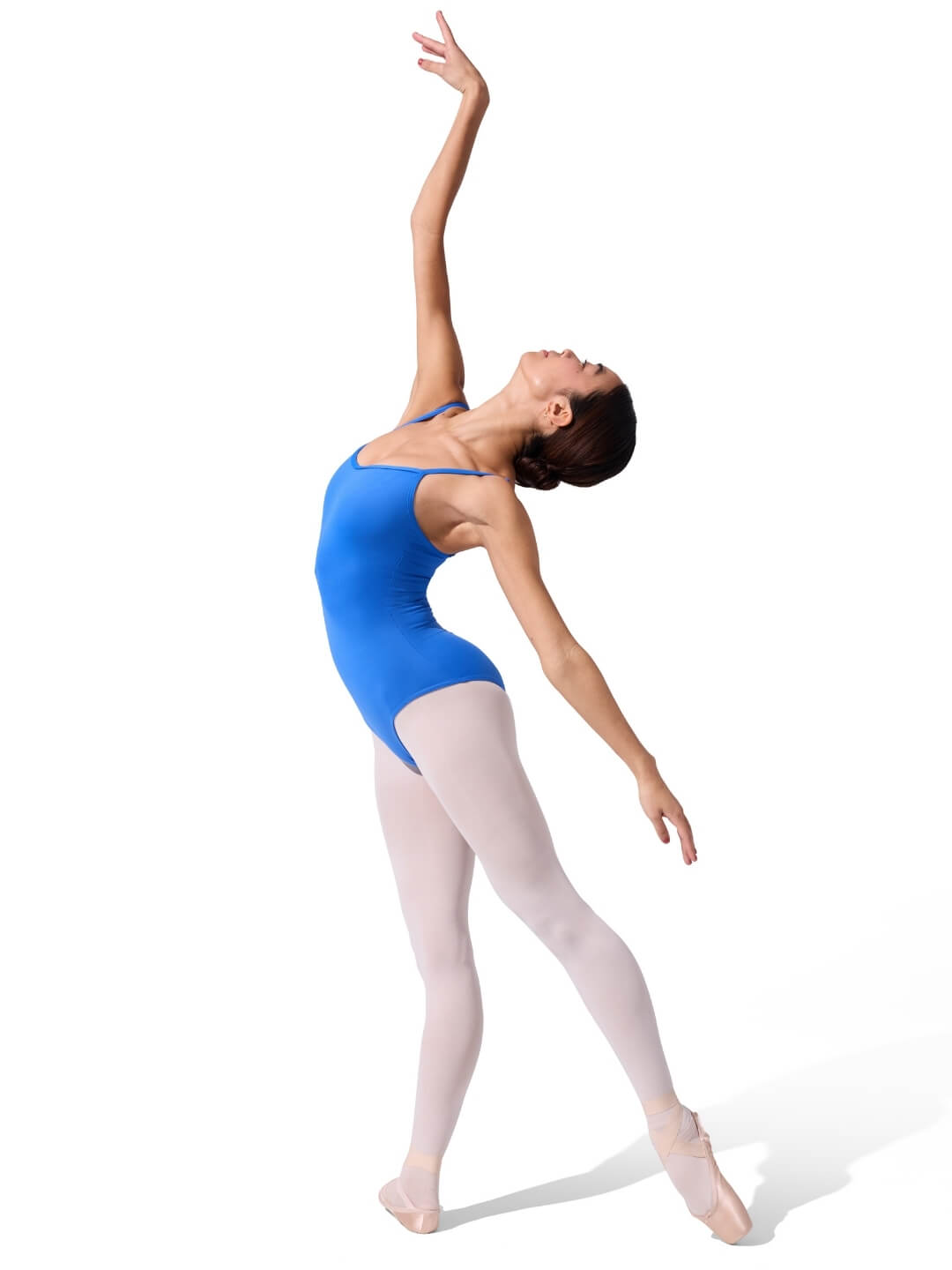 Ballerina in a blue leotard and white tights posing on a white background