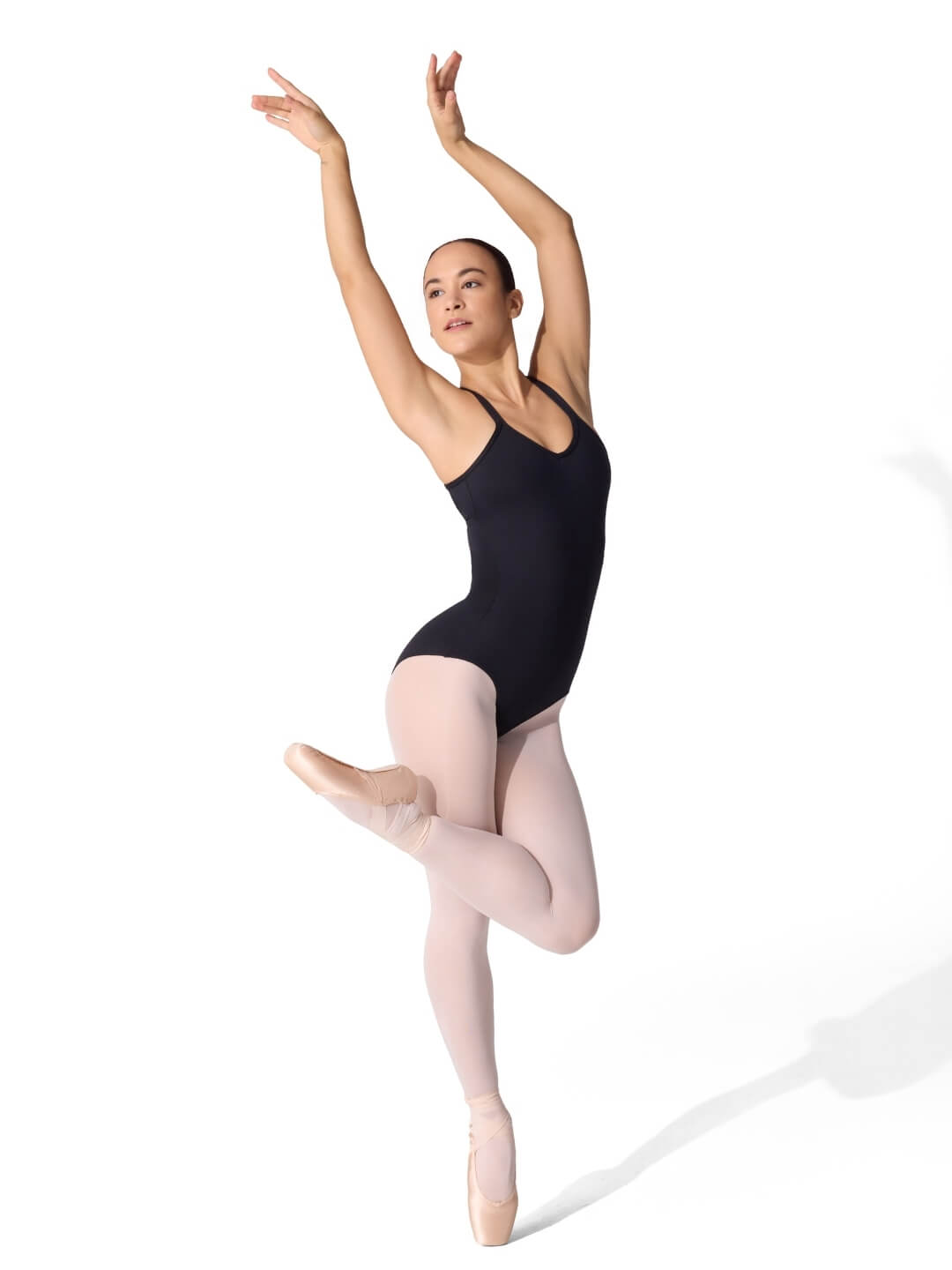 Ballerina in a black leotard and pink tights posing against a white background