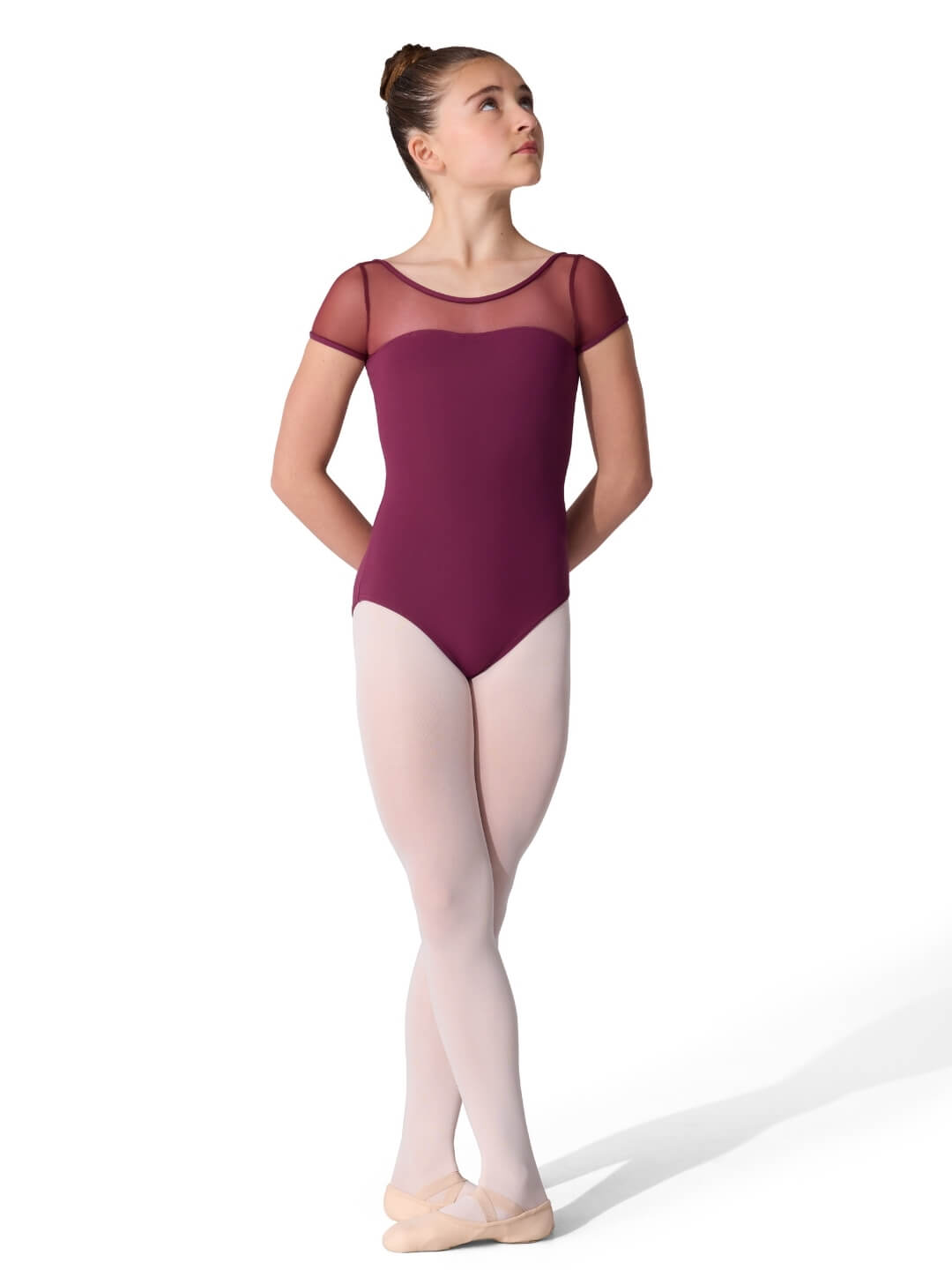 Ballerina wearing a maroon leotard with sheer sleeves on a white background