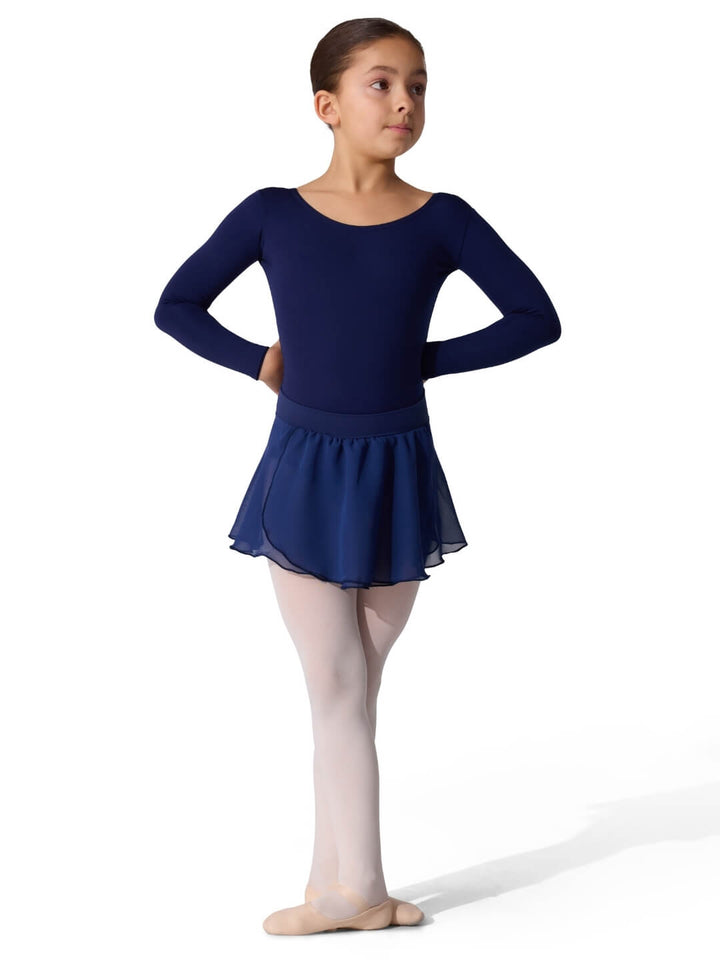 Young girl in a navy blue leotard and skirt on a white background