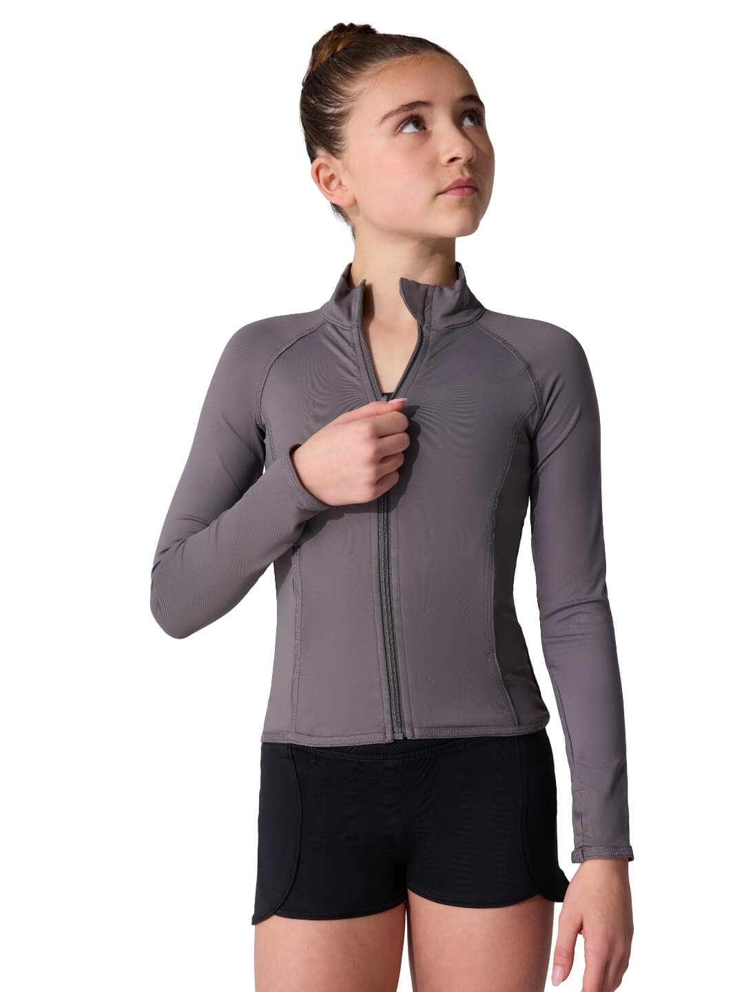 Woman wearing a gray athletic jacket and black shorts on a white background