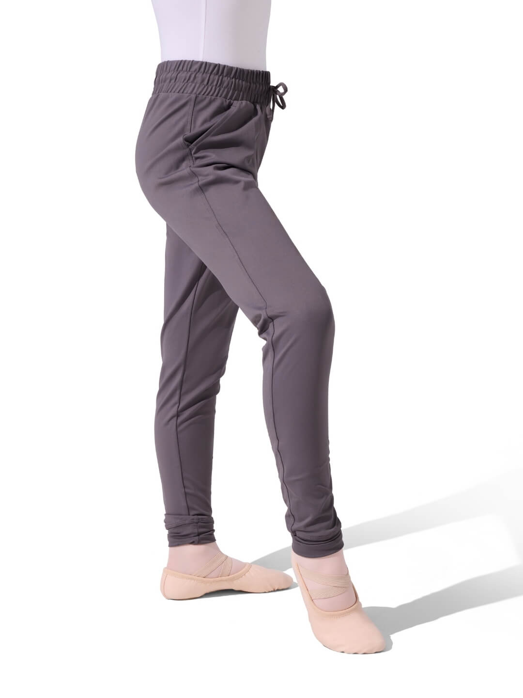 Gray dance pants worn by a person on a white background