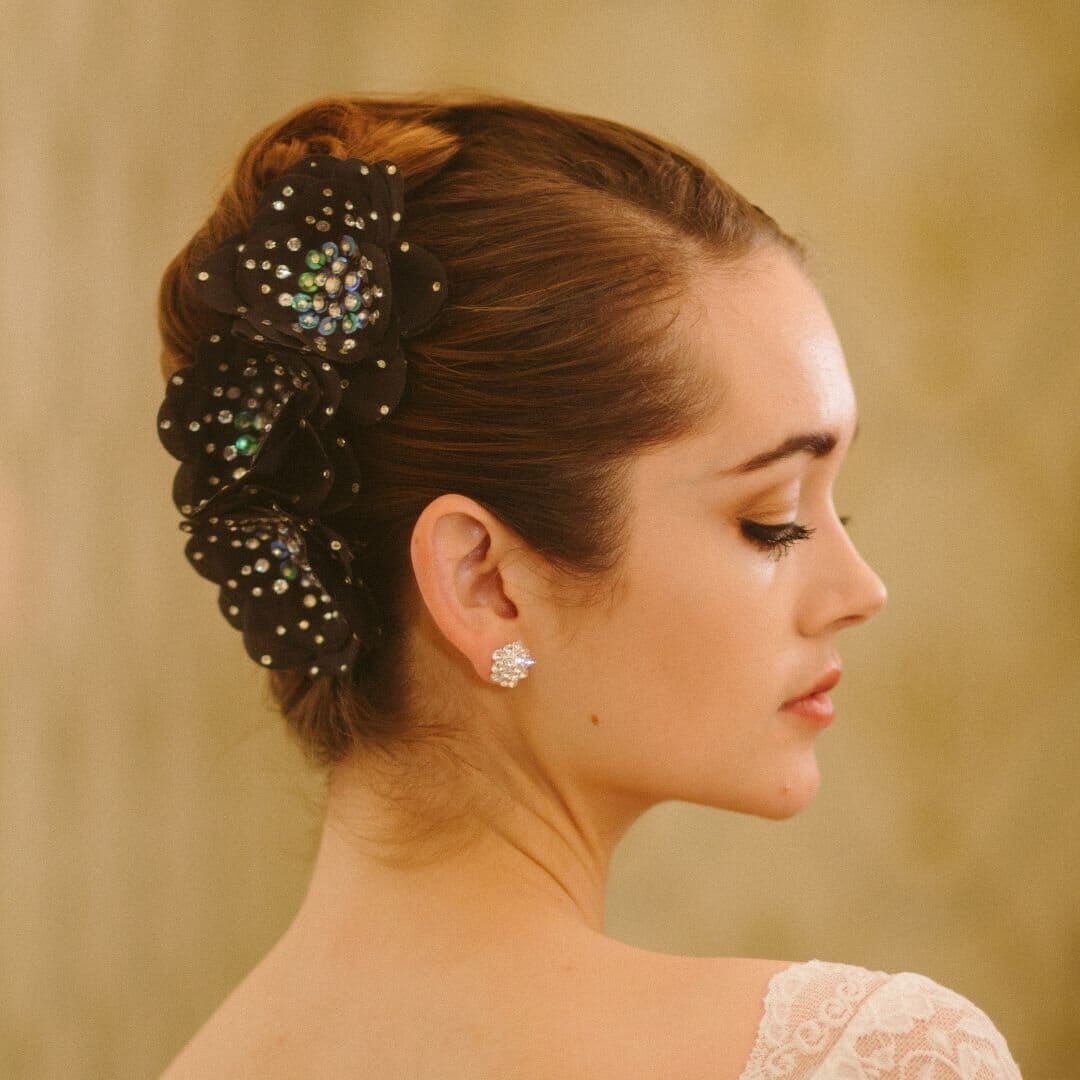 Woman with elegant hair accessory and earrings against a beige background