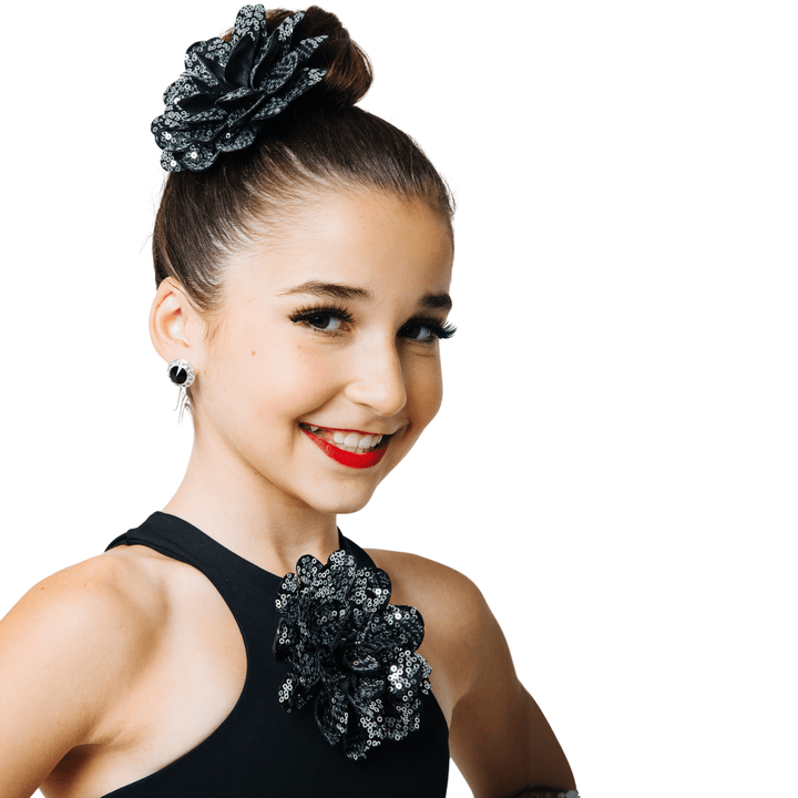 Woman wearing a black dress with floral embellishments on a white background